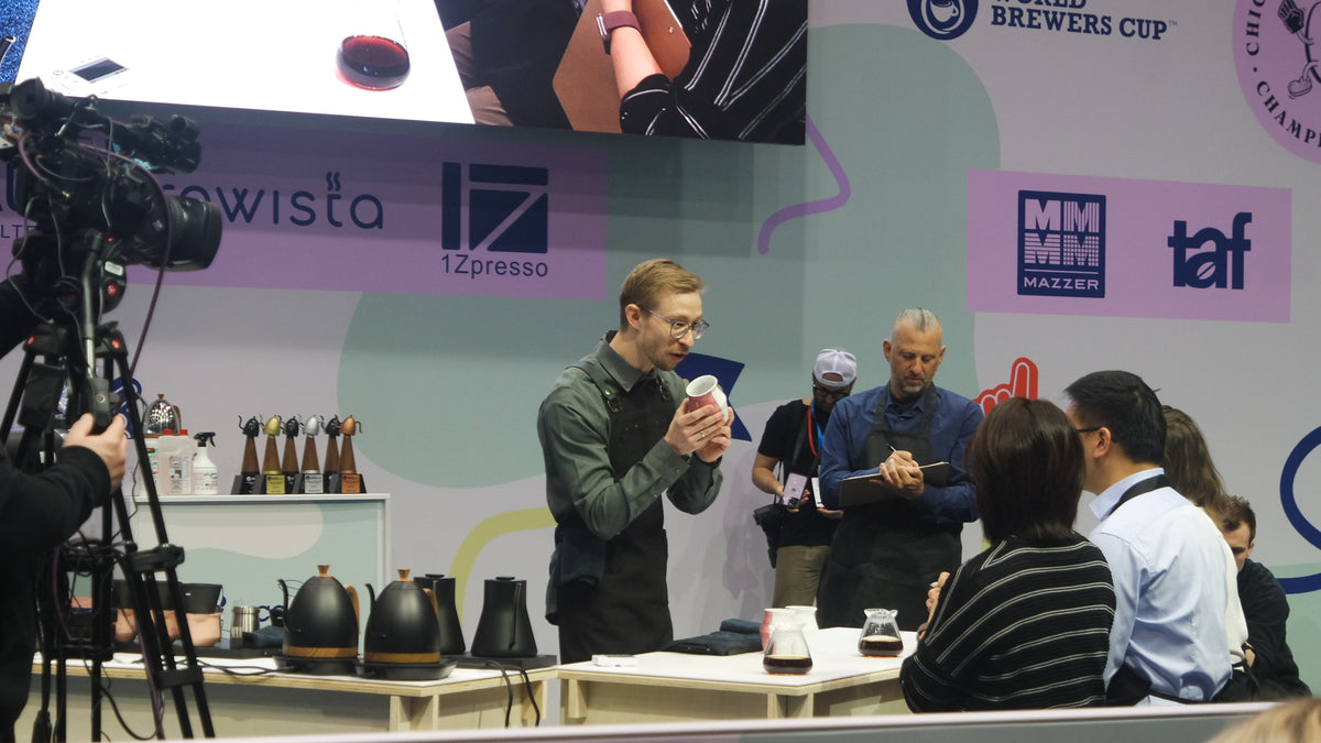 Person zeigt einer Jury 2-waycup-Tasse